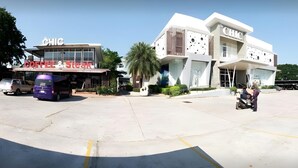 Un parcheggio con un edificio con la scritta "CHIC COFFEE & Steak" e un altro edificio con il marchio "CHIC".