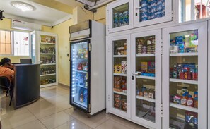 Une pharmacie dotée de rayons réfrigérés et d’étagères remplies de divers produits.