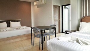 A hotel room with a bed, a small table with chairs, an air conditioning unit, and a door with a window. - Zleep D Hotel (Udon Thani)