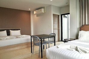 A hotel room with a bed, a small table with chairs, an air conditioning unit, and a door with a window. - Zleep D Hotel (Udon Thani)