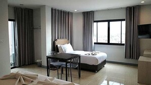 A hotel room with a bed, a desk, a chair, a TV, and a window. - Zleep D Hotel (Udon Thani)