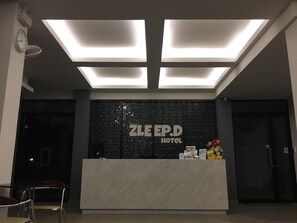 Un comptoir d’accueil d’hôtel avec une pancarte indiquant « HÔTEL ZLEP.D ».