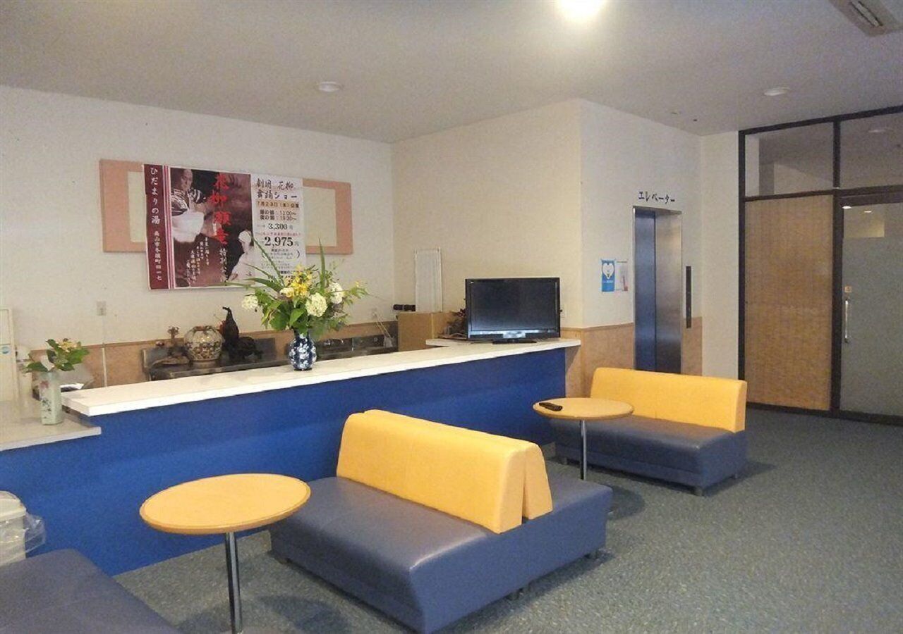 A reception area with a counter, a television, and seating.