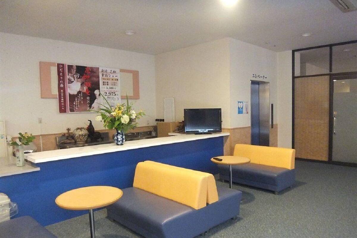 A reception area with a counter, a television, and seating.