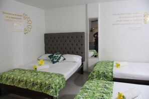 A hotel room with a large bed, two smaller beds, and a mirror. - Rodadero Dorado (Santa Marta)