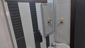 A bathroom with a toilet, a sink, and a mirror.