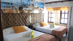 A hotel room with two beds, a large cityscape mural, a window with curtains, and a view of the city. - Rodadero Dorado (Santa Marta)