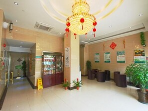 A hotel lobby with a reception desk, seating area, and a large chandelier. - Greentree Inn Shanghai National Convention Center Xinfu Middle Road Huazhi Road Hotel (Shanghai)