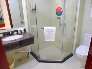 A modern bathroom with a glass-enclosed shower, a white toilet, and a marble sink with soap dispensers. - Greentree Inn Shanghai National Convention Center Xinfu Middle Road Huazhi Road Hotel (Shanghai)