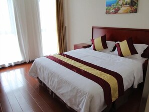 A hotel room with a large bed, a nightstand, a painting on the wall, and a window with curtains. - Greentree Inn Shanghai National Convention Center Xinfu Middle Road Huazhi Road Hotel (Shanghai)