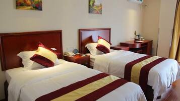 Quarto de hotel com duas camas, mesa de cabeceira e ar-condicionado fixado na parede.