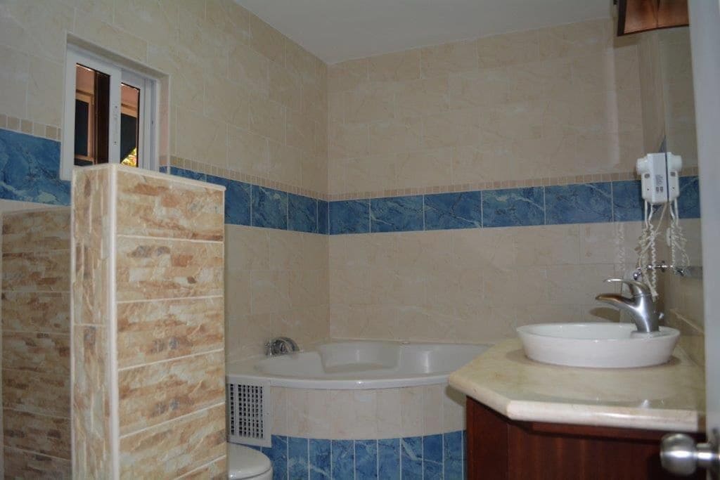 A bathroom with a bathtub, a sink, and a shower area.