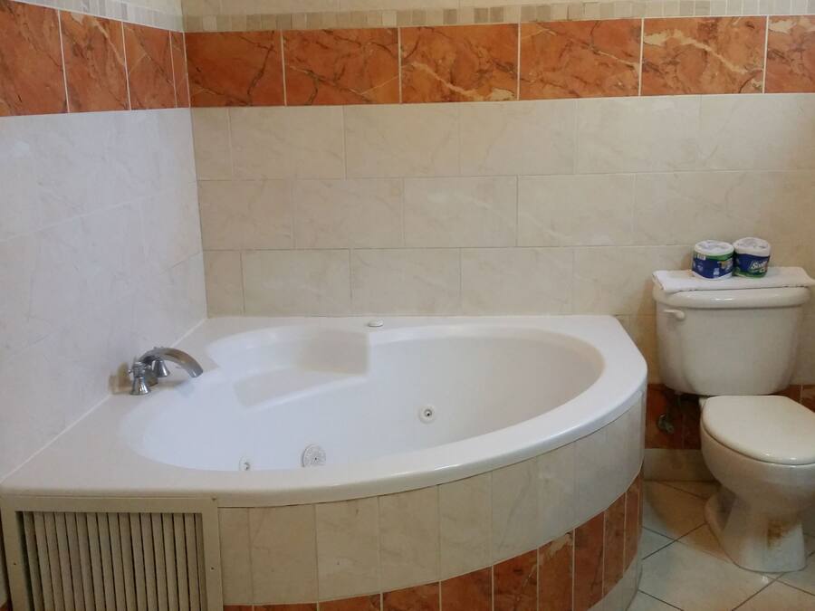 Een badkamer met een bad, toilet en wastafel.