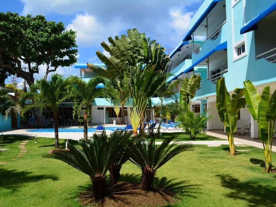 Ein Hotel mit Pool, Palmen und einem blauen Gebäude.