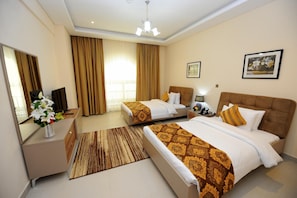 A hotel room with two beds, a desk, a mirror, a nightstand, and a window with curtains. - Al Mansour Park Inn Hotel Apartment (Doha)