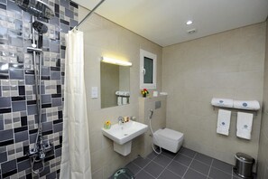 Un baño moderno con ducha, inodoro, lavabo y toallero.