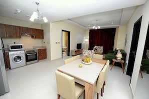 A compact living space with a kitchen, dining area, and a living room. - Al Mansour Park Inn Hotel Apartment (Doha)