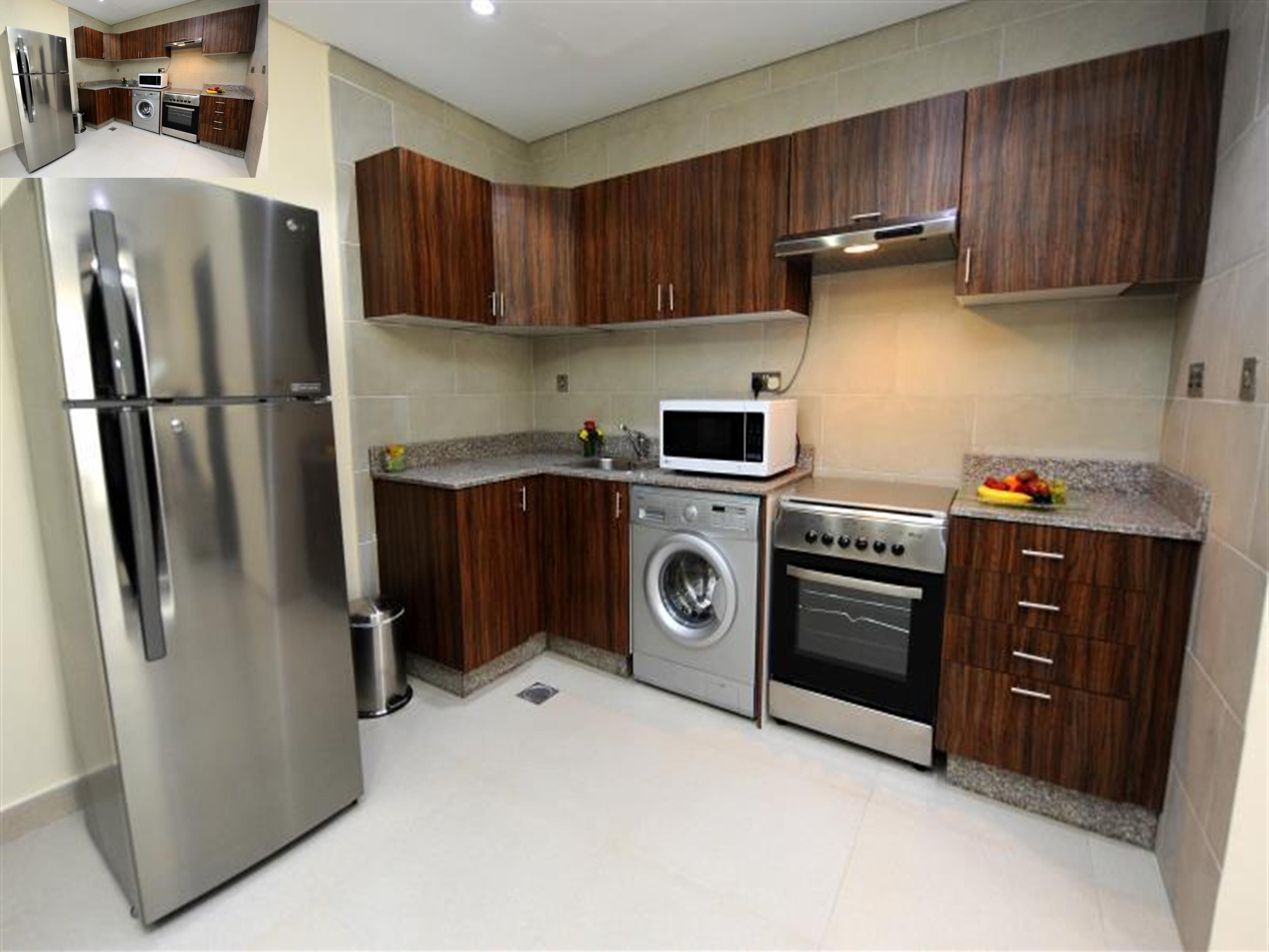 A modern kitchen with stainless steel appliances, wooden cabinets, and a granite countertop.