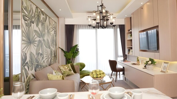 A modern living room with a sofa, dining table, and a kitchen area with a TV. - Senyum World Hotel (Batu)
