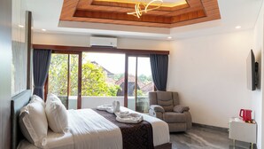 Una camera d'albergo moderna con un letto grande, un divano, una TV e vista sul verde.