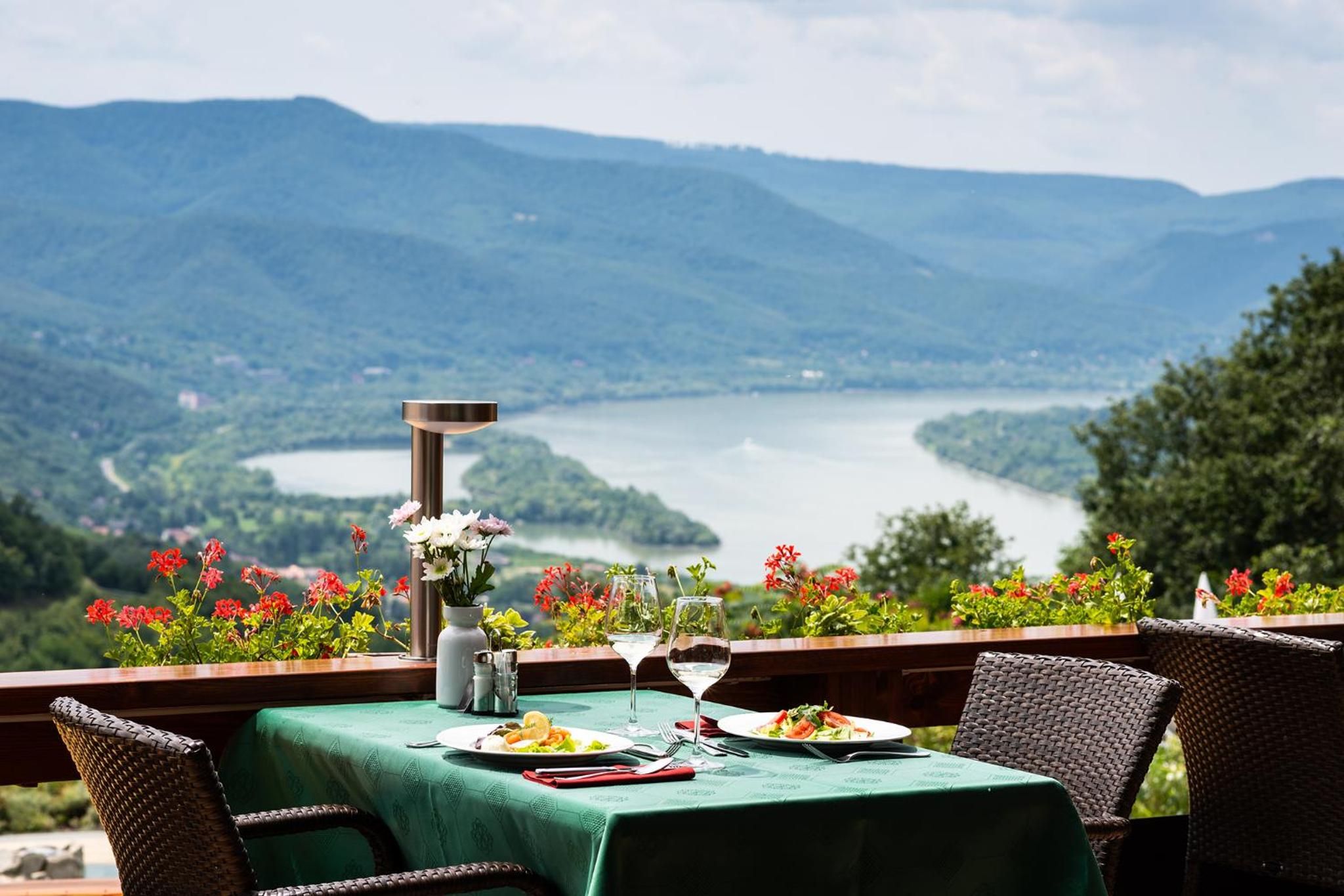 Mesa al aire libre con vista a un lago y montañas.