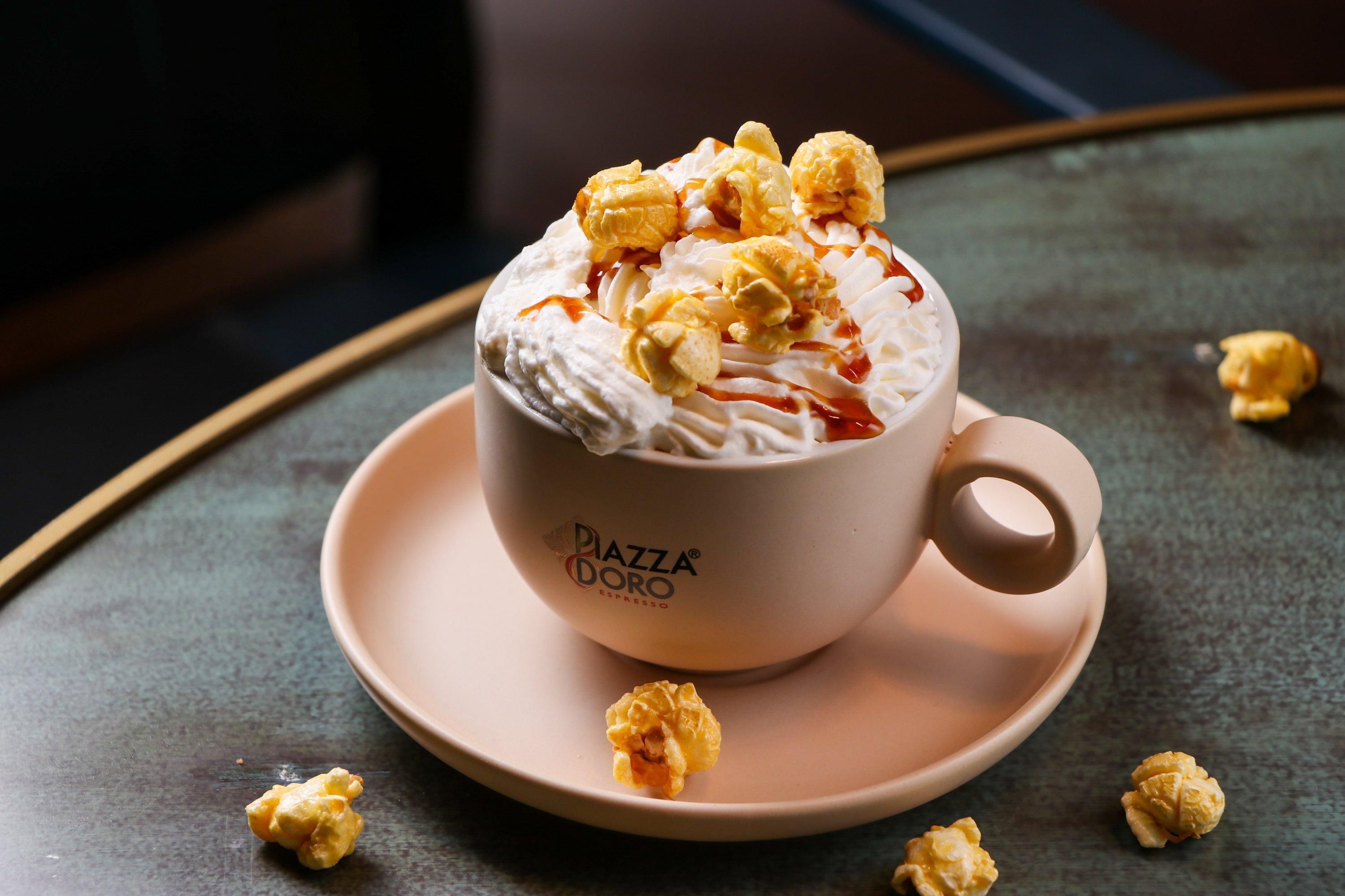 A cup of coffee with whipped cream and caramel on a saucer.