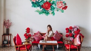 A room with a sofa set, a small table, and a wall-mounted floral decoration. - Sleeper House (Trang)