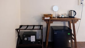 A compact kitchenette with a refrigerator, a microwave, and a kettle on a wooden table. - Sleeper House (Trang)