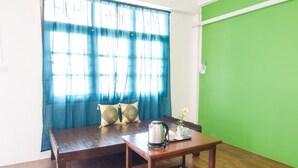 A room with a wooden table, a bench, and a green wall. - Sleeper House (Trang)