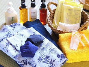 A neatly arranged set of bath products including bottles and bars, towels, and a basket. - Hotel Housei (Yamanouchi)