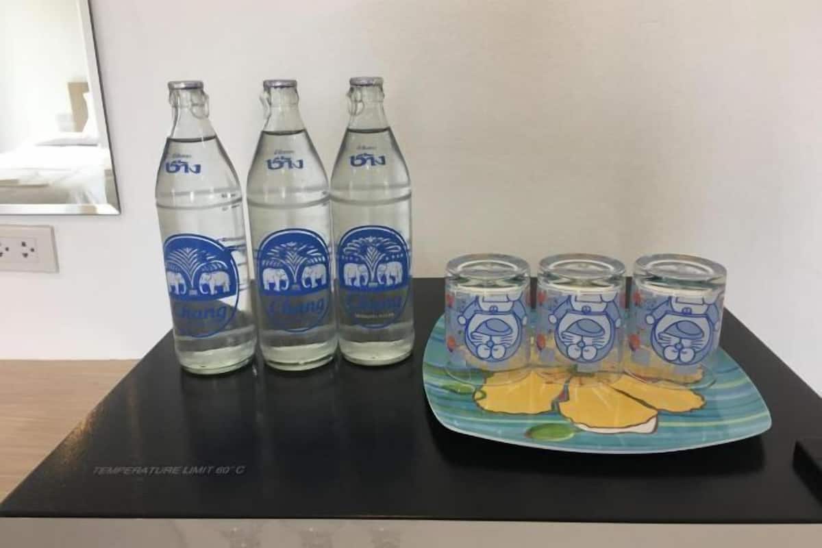 Three bottles and four glasses with a cartoon character on a black surface.
