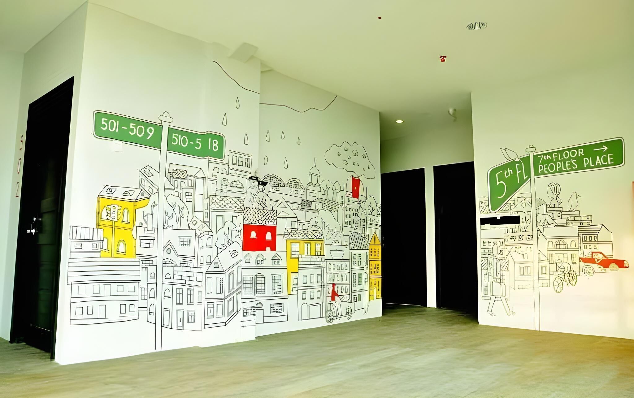 A hallway with a large mural of a cityscape, including street signs and buildings.
