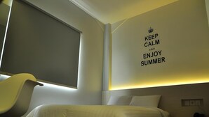 A bedroom with a bed, a chair, a window, and a wall with a motivational quote. - Summer Bed and Breakfast Hotel (Banjarmasin)
