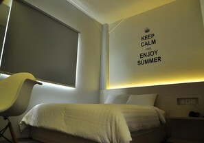 A bedroom with a bed, a chair, a window, and a wall with a motivational quote. - Summer Bed and Breakfast Hotel (Banjarmasin)