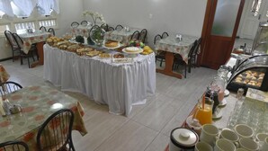 Un espace repas comprenant plusieurs tables, des chaises et un buffet.