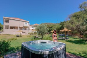 A hot tub in a backyard with a house in the background. - Maison Del Sole (Quartu Sant'Elena)