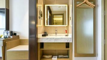 A modern bathroom with a vanity, mirror, and built-in shelves.