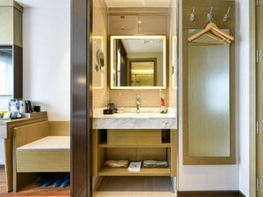 Une salle de bain moderne avec un meuble-lavabo, un miroir et des étagères intégrées.