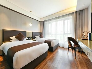 Une chambre d’hôtel avec deux lits, un bureau et une chaise.