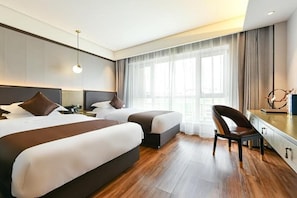 A hotel room with two beds, a desk, a chair, and a large window with curtains. - GYA Langfang Art Avenue Civic Service Center Daxing International Airport Hotel (Langfang)