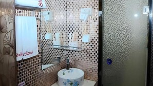 A bathroom with a tiled wall, a sink, and a mirror. - Shell Shanghai Jiading District Tongji University Xinhuang Road Hotel (Shanghai)