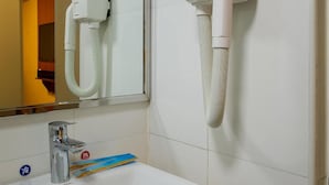 A bathroom with a white sink, a mirror, and two hair dryers mounted on the wall. - 7 Days Premium (Shenzhen)