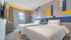 A hotel room with two beds, a desk, a chair, a TV, and a window with curtains. - 7 Days Premium (Shenzhen)