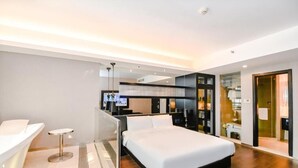 A modern hotel room with a large bed, a desk, and a glass partition separating the bedroom from the bathroom. - Crystal Orange Intl. Tourist Resort (Shanghai)