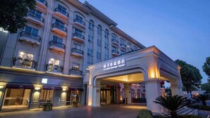 A hotel with multiple floors, a prominent entrance, and a sign indicating it is the Crystal Orange Hotel. - Crystal Orange Intl. Tourist Resort (Shanghai)