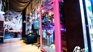 A vibrant arcade area with claw machines and a large TV screen. - Fenk Attitude Hotel (Guangzhou)
