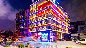 A multi-story hotel with illuminated signage and a prominent 'HOTEL' sign on the facade. - Fenk Attitude Hotel (Guangzhou)