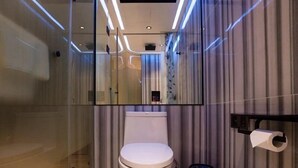 A modern bathroom with a toilet, a glass shower enclosure, and a mirror. - Fenk Attitude Hotel (Guangzhou)