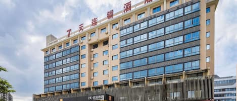 Un hotel de varios pisos con un llamativo letrero con el número '7', que indica que es el séptimo edificio de una serie.
