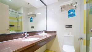 A bathroom with a marble countertop, a white sink, a white toilet, and a glass shower enclosure. - 7 Days Premium·xiamen Airport (Xiamen)